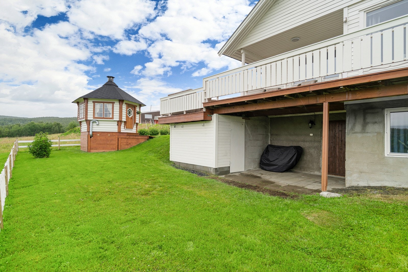 Den store tomten gir god plass til lek, hage eller rekreasjon, mens verandaen og grillhytta skaper perfekte rammer for å nyte både sommer- og vinterkvelder.