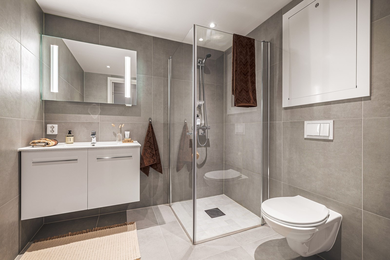 Lekkert påkostet bad med 60x60 fliser | Merk det flotte speilet med integrert belysning | Naturligvis varme i gulvet Galleribilde