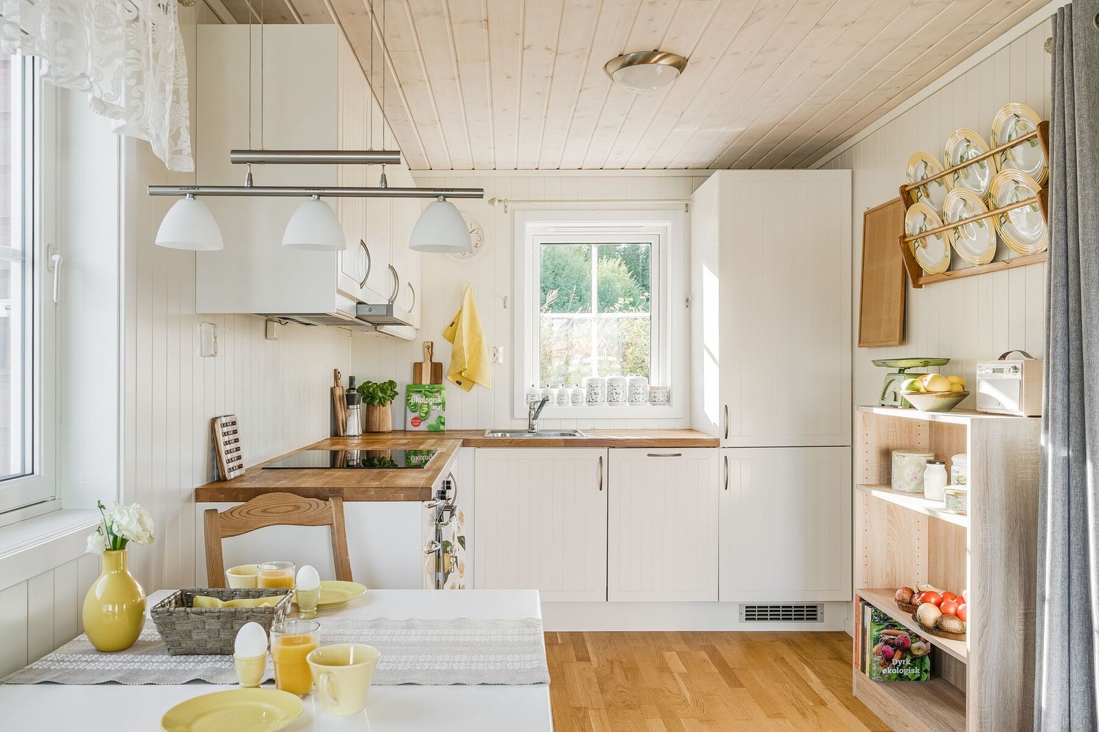 Stilrent og klassisk hvitt kjøkken med integrerte hvitevarer og heltre benkeplate. Galleribilde