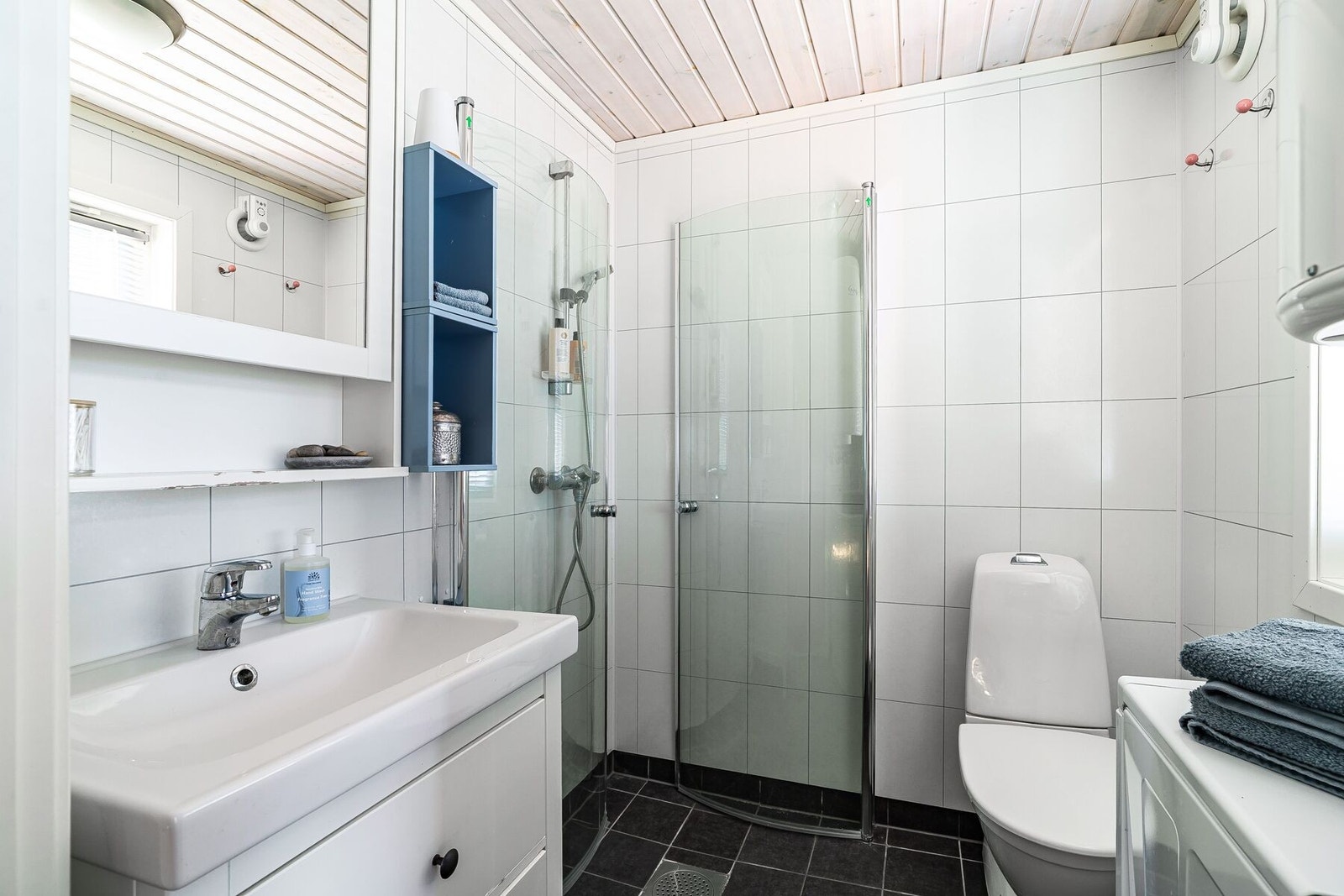 Lyst og pent bad med flislagt gulv med varme og våtromsplater på vegg. Galleribilde