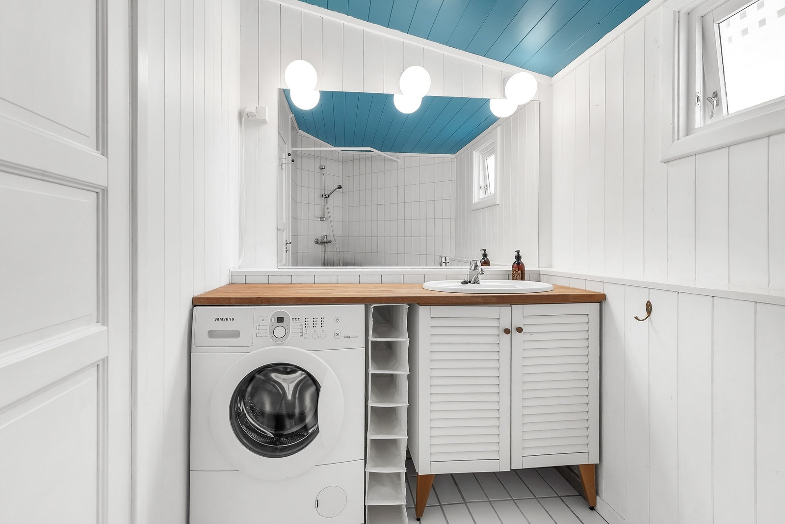Baderom flislagt gulv med varme. Veggflater med fliser og malt panel. Skråtak med malt panel. Vegghengt servantskap med profilerte fronter. Benkeplate av heltre. Nedsenket servant med ett-greps armatur. Ikke godkjent for varig opphold. Galleribilde