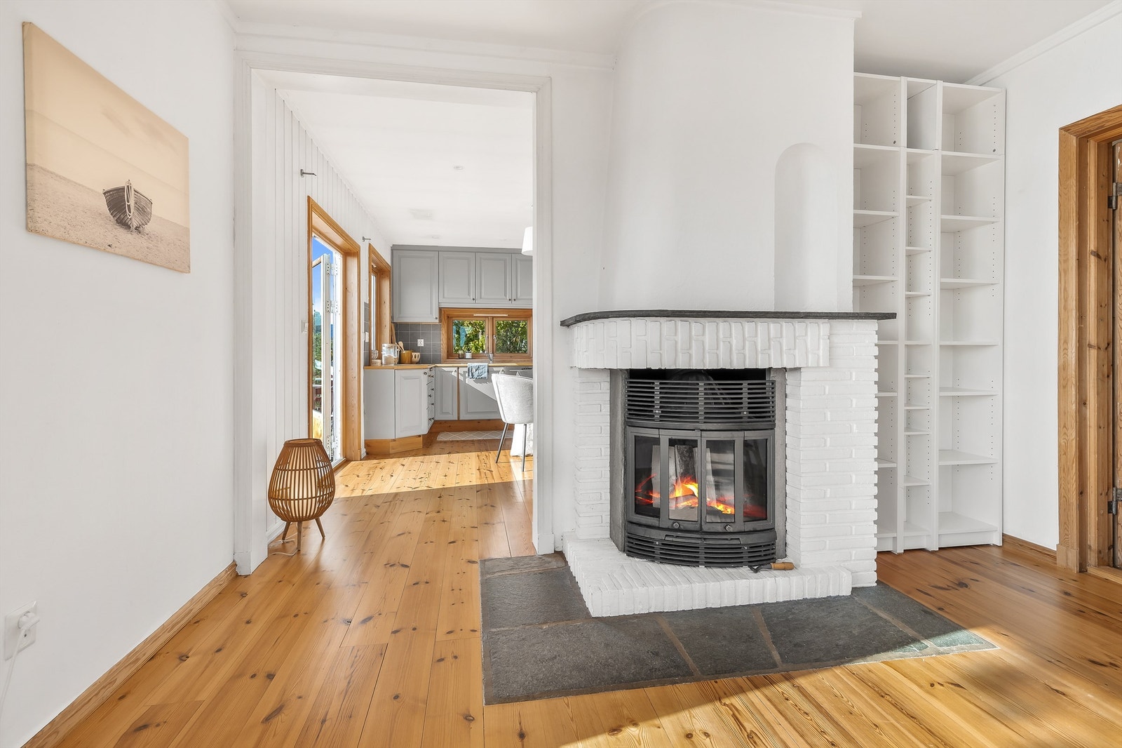 Peisovn for ekstra varme og hygge på kalde dager. Bak bokhyllene er det også gjennomgang til kjøkkenet hvis man ønsker å åpne mer opp. Galleribilde