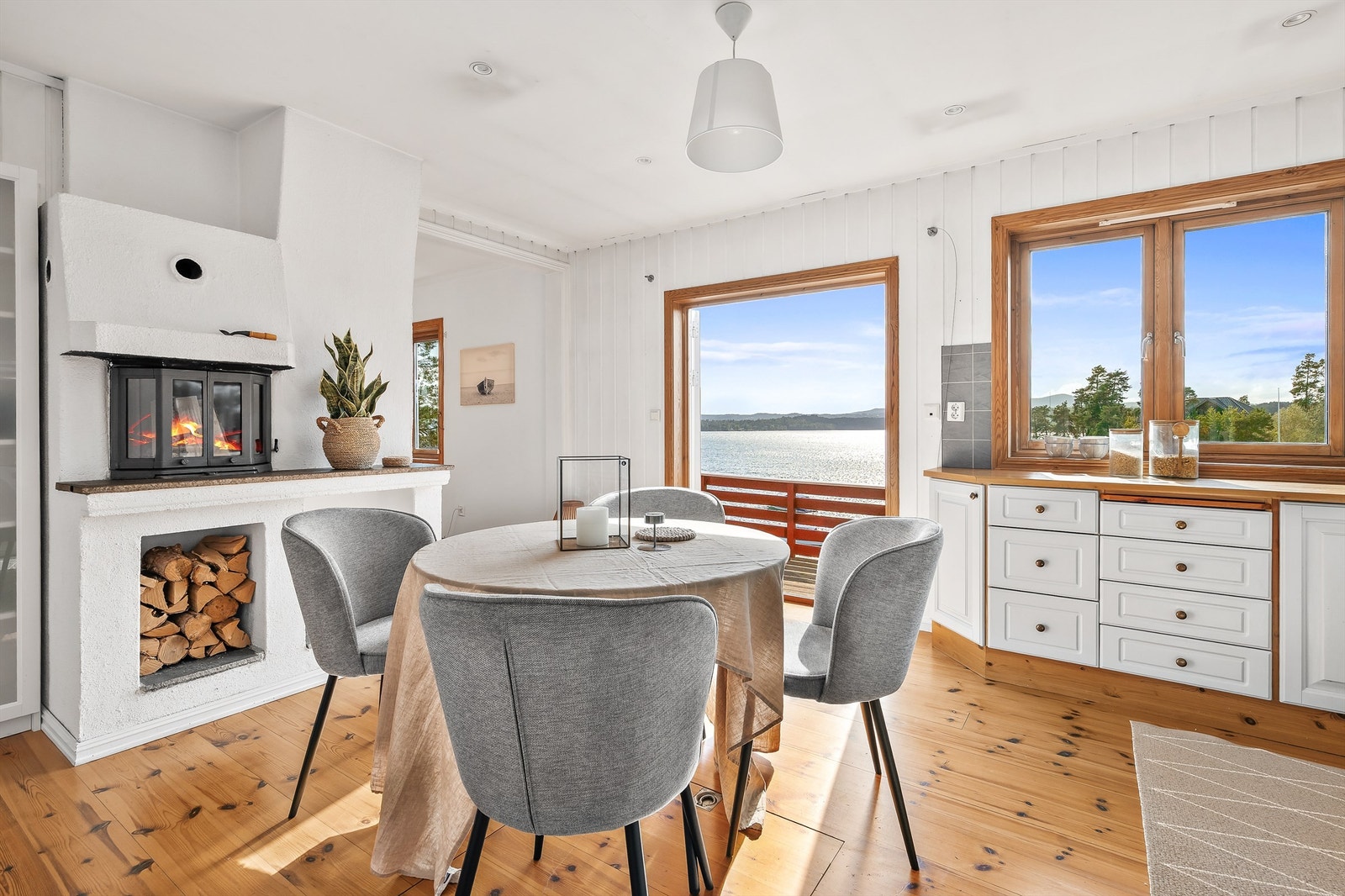 Stort kjøkken med peis og dører som åpnes mot fjorden. Galleribilde