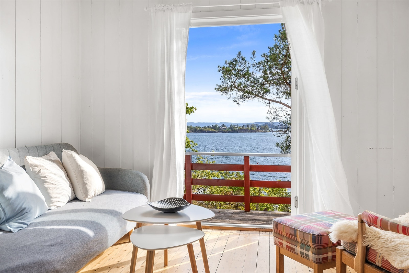 Panoramautsikt over sjøen med direkte utgang til hage og terrasse. Rom innredet som stue. Ikke godkjent for varig opphold. Galleribilde