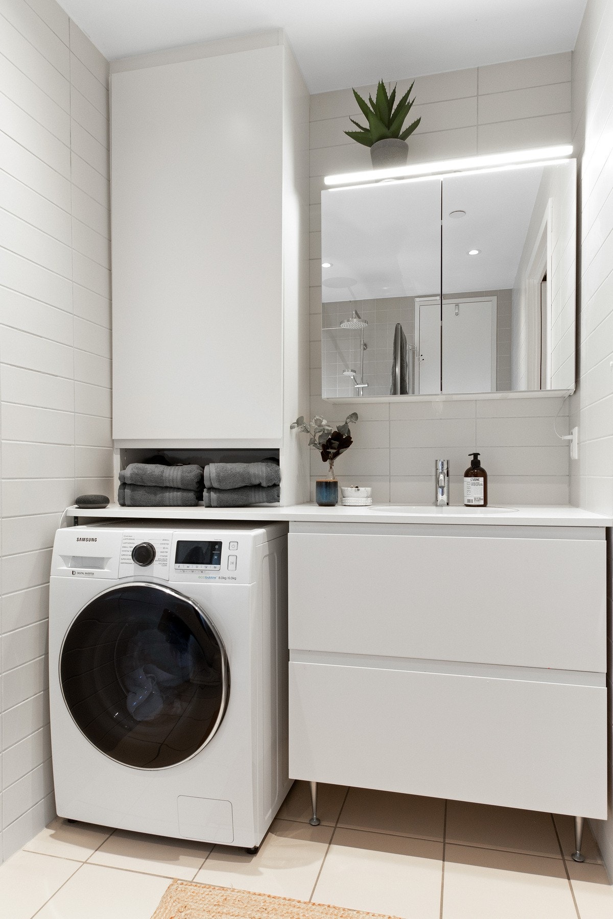 En praktisk nisje gir plass til vaskemaskin i tillegg til hyller for oppbevaring. Galleribilde