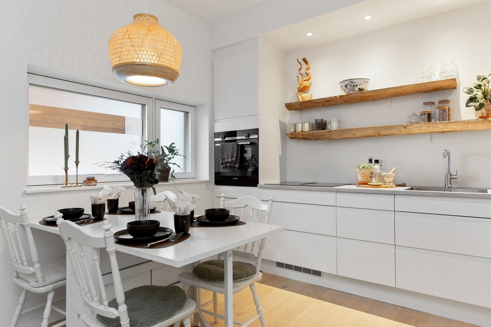 Innredningen har hvite, slette fronter og en laminert benkeplate med nedfelt kum. Galleribilde