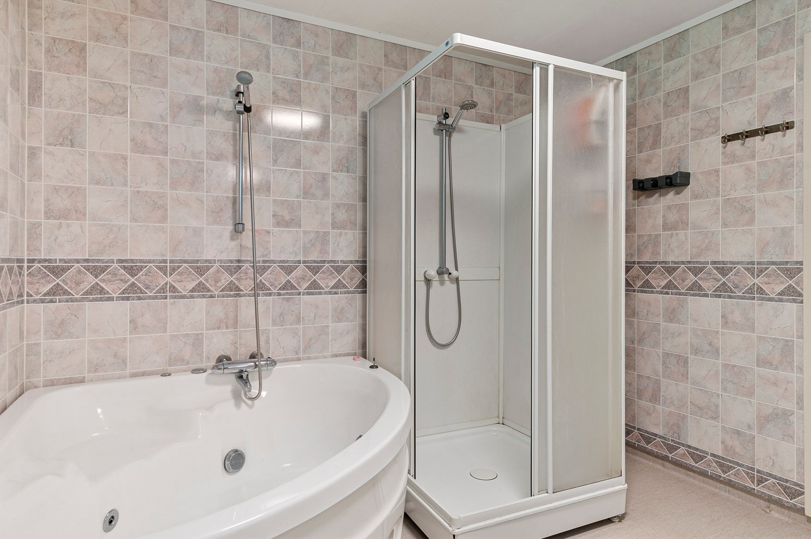 Badet har dusjkabinett og hjørnebadekar Galleribilde