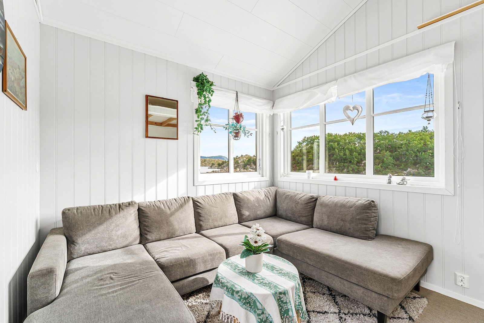 På eiendommen står også et hyggelig anneks, innredet med sofa og oppbevaringsplass. Galleribilde