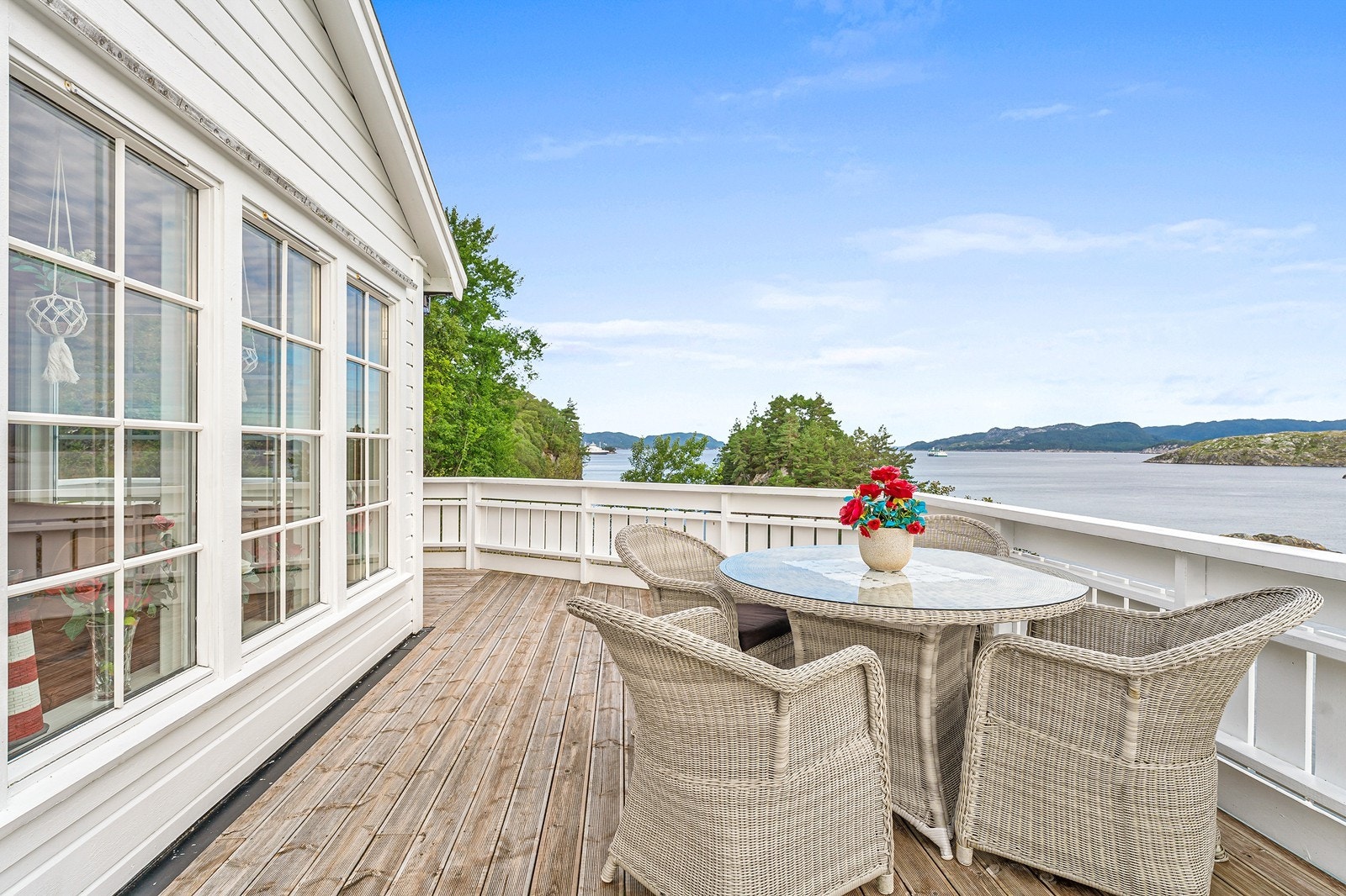 Herfra kan man nyte den storslåtte utsikten over både sjø og fjell, og terrassen blir en naturlig forlengelse av oppholdsrommet på varme sommerdager. Galleribilde