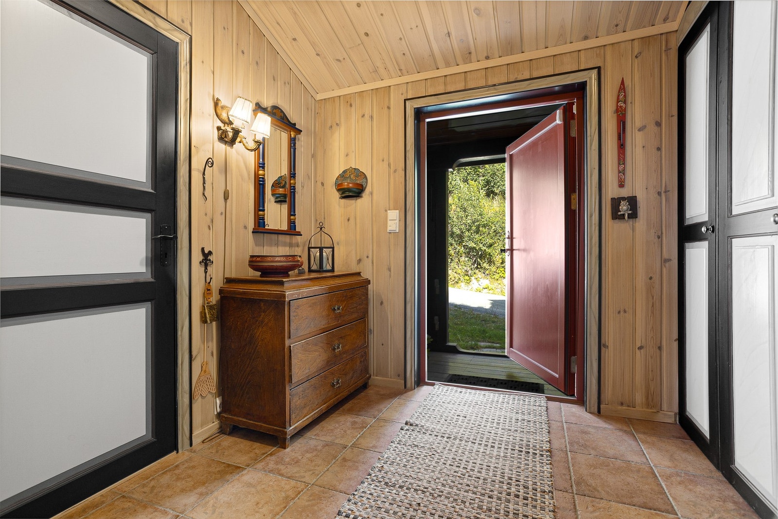 Innbydende og romslig entré med flislagt gulv med varmekabler og plassbygde garderobeskap Galleribilde