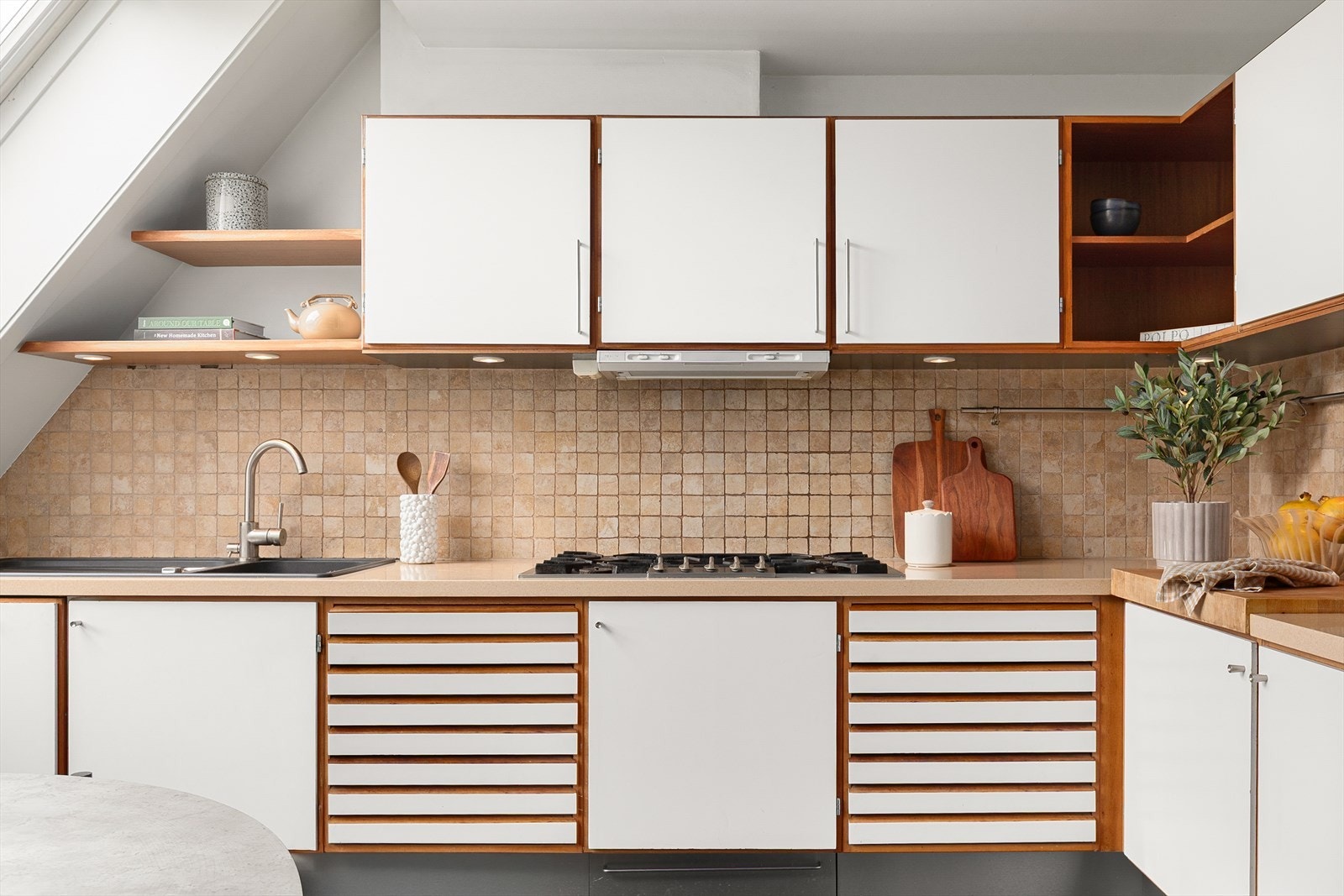 Kjøkkeninnredning med glatte fronter og benkeplate med nedfelt kum Galleribilde