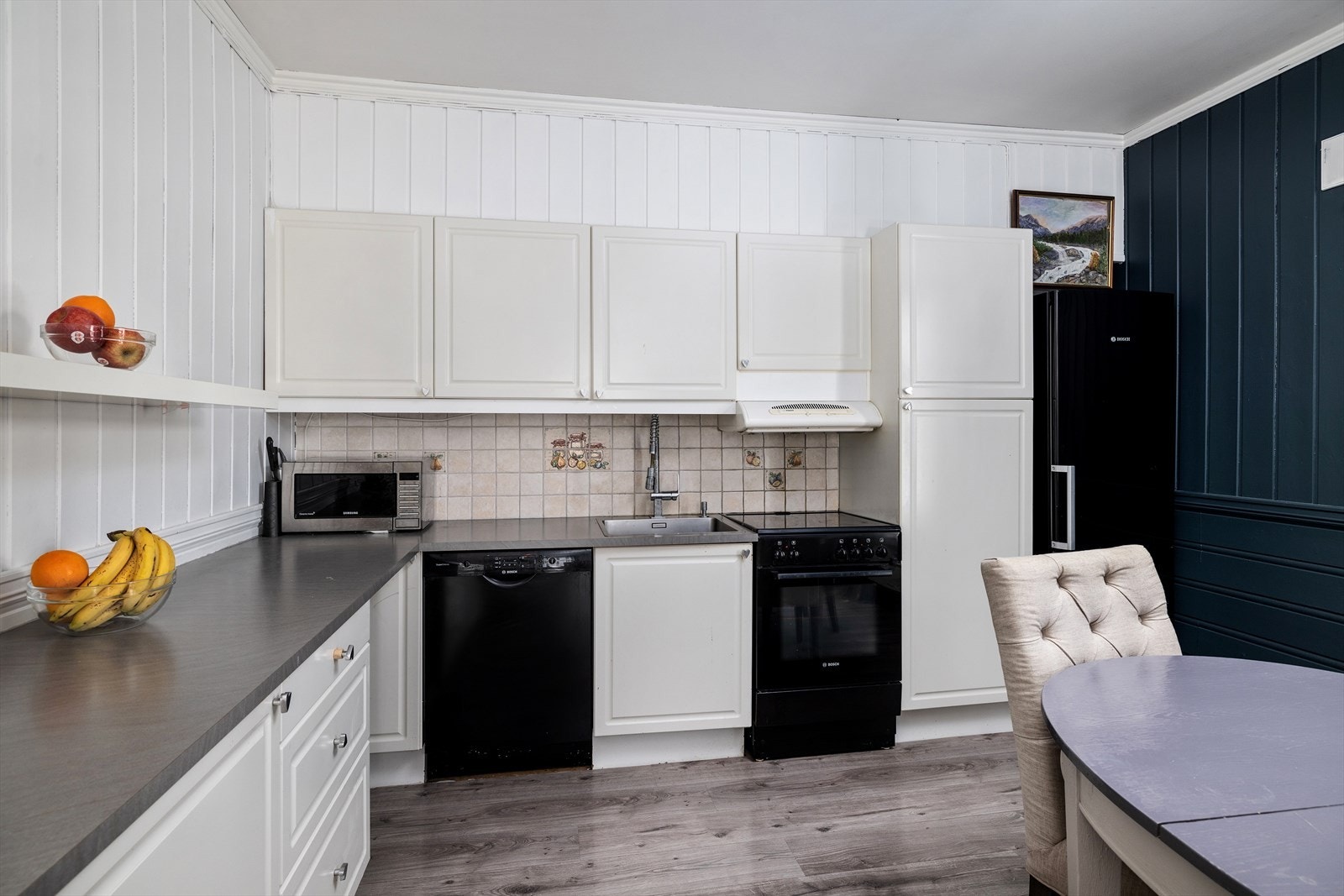 Kjøkkenet har en innredning med malte, profilerte fronter og benkeplate i laminat. Galleribilde