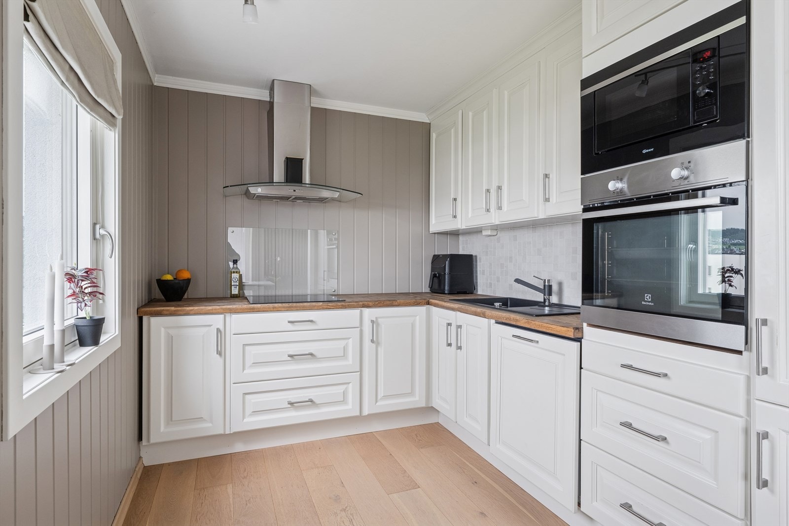 Fliser og belysning over benk. Spiseplass ved vindu. Galleribilde