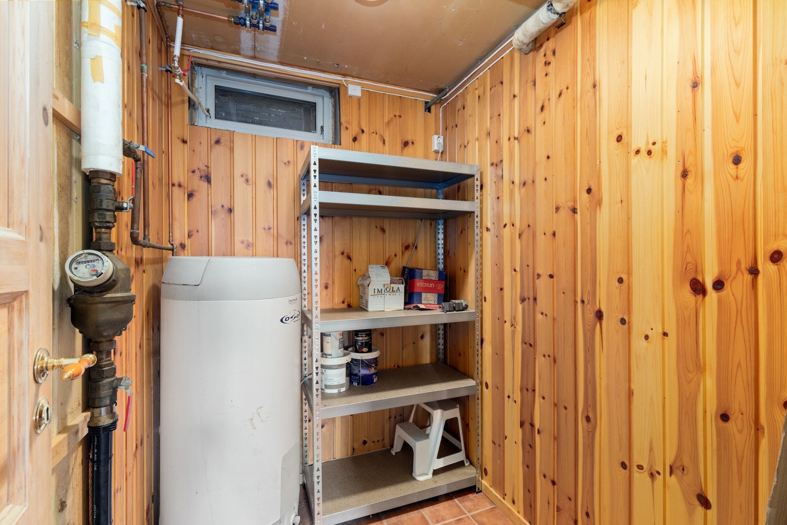 Bod/teknisk rom som inneholder sikringsskap, varmtvannsbereder og plass til oppbevaring/lagring. Galleribilde