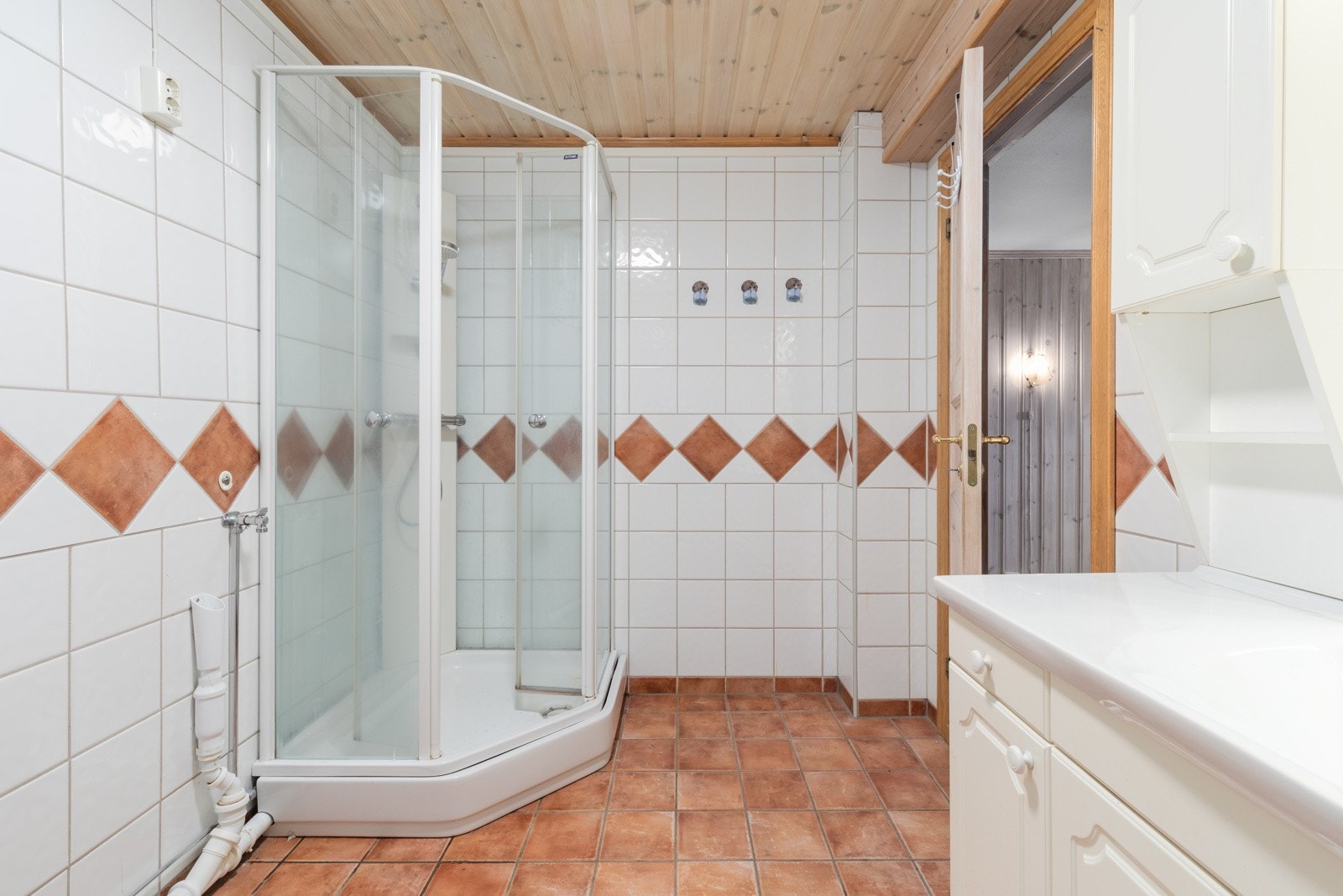 Bad med varme i gulv, vegghengt servantinnredning og opplegg for vaskemaskin. Mekanisk avtrekksvifte i vegg. Galleribilde