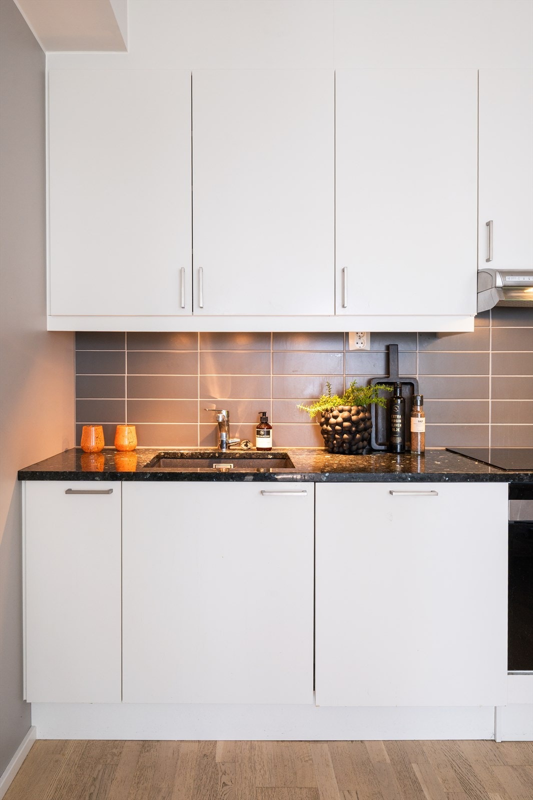 Kjøkkeninnredningen er av glatte fronter, benkeplate av granitt og fliser mellom kjøkkenbenk og overskap. Galleribilde