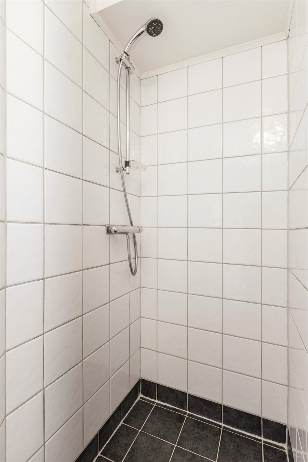 Badet er fra 2003 med elektriske varmekabler. Innredningen består av et underskap, servant, speil, lys, dusjsone. Galleribilde