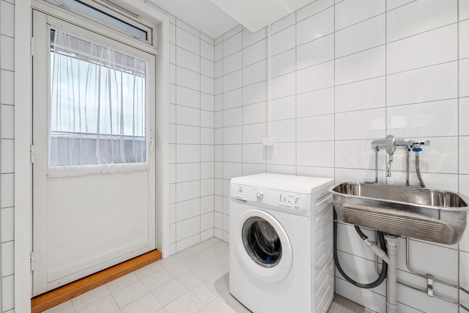 Vaskerommet er også flislagt med downlights i tak og elektriske varmekabler i gulv. Vaskerommet er innredet med utslagskum og opplegg for vaskemaskin og tørketrommel. Galleribilde