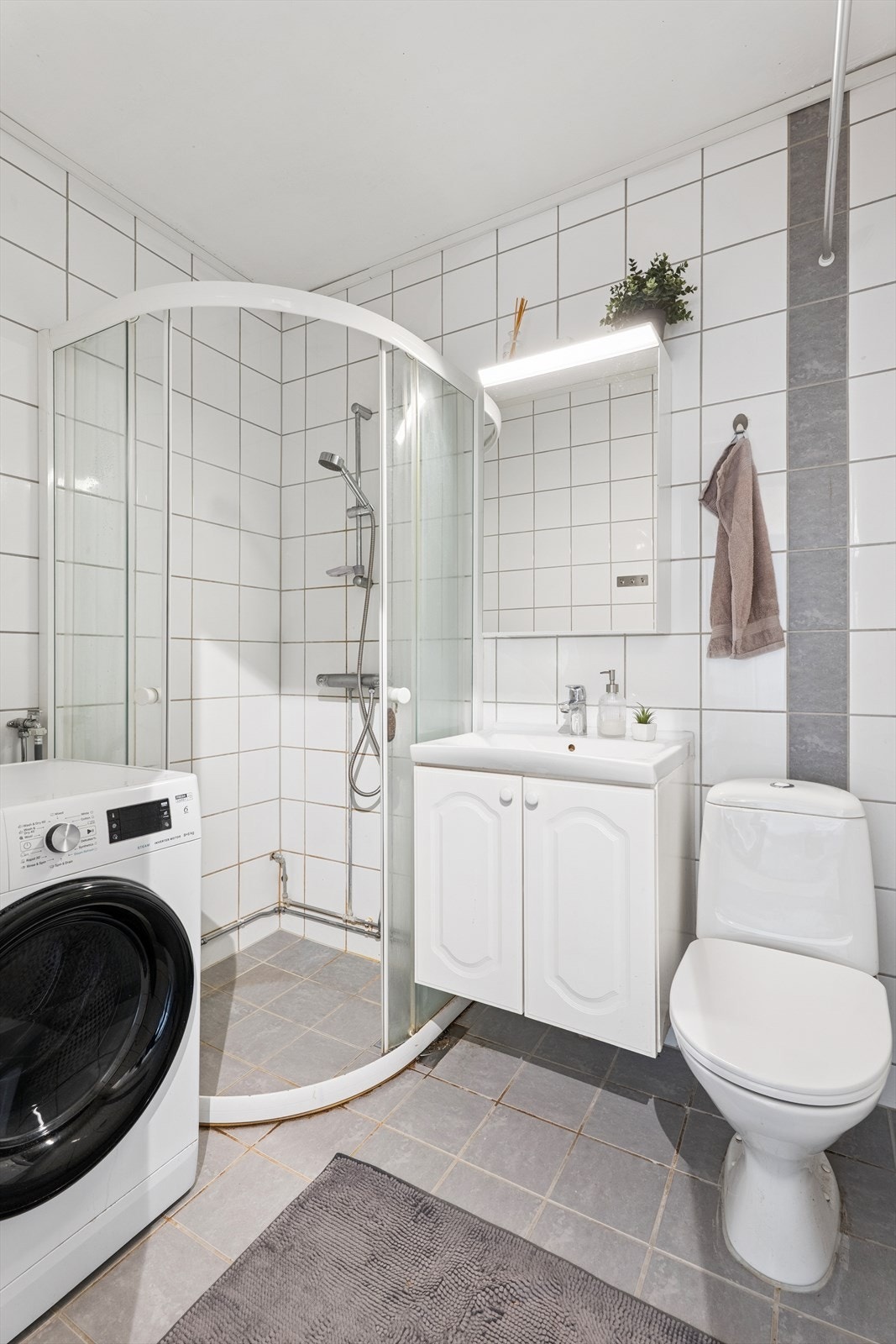 Flislagt bad fra 2014 med dusjhjørne og opplegg for vaskemaskin. Galleribilde