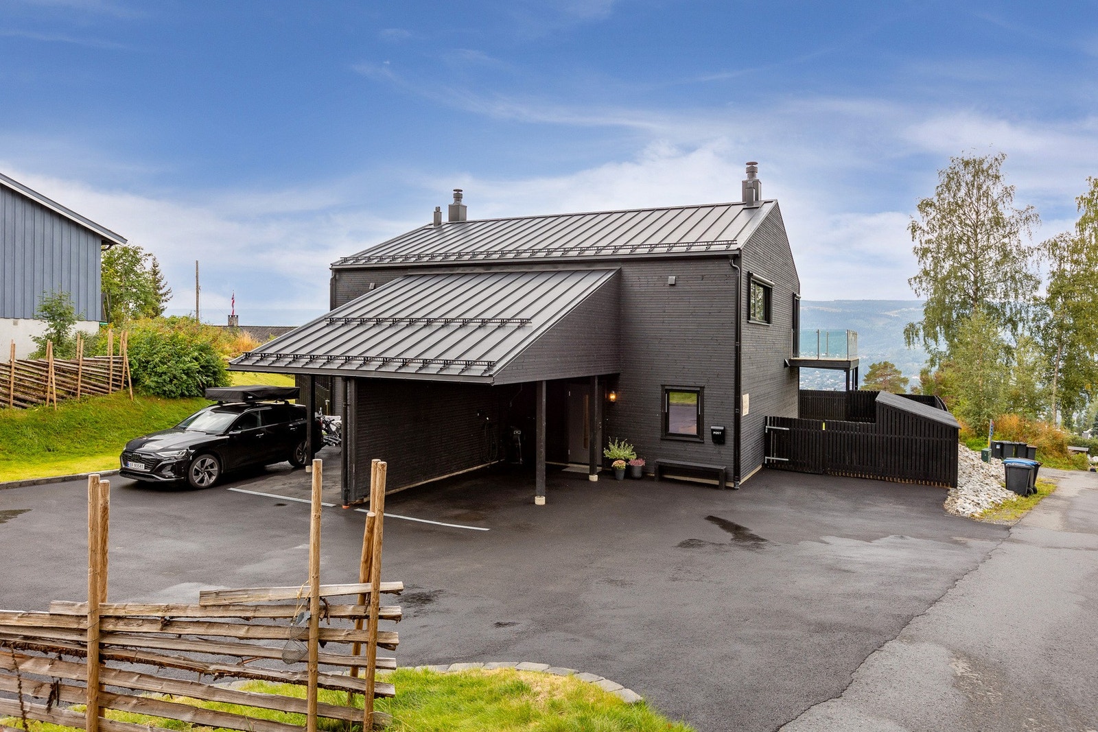 Romslig asfaltert gårdsplass med carport. Galleribilde
