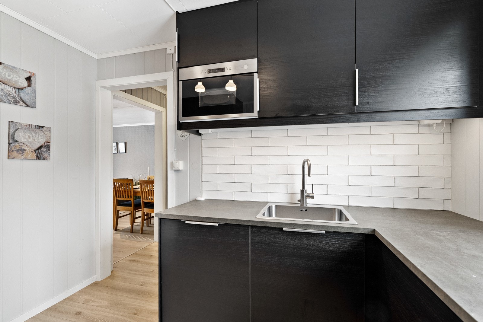 Det er fliser og ekstra belysning mellom benk og overskap. Galleribilde