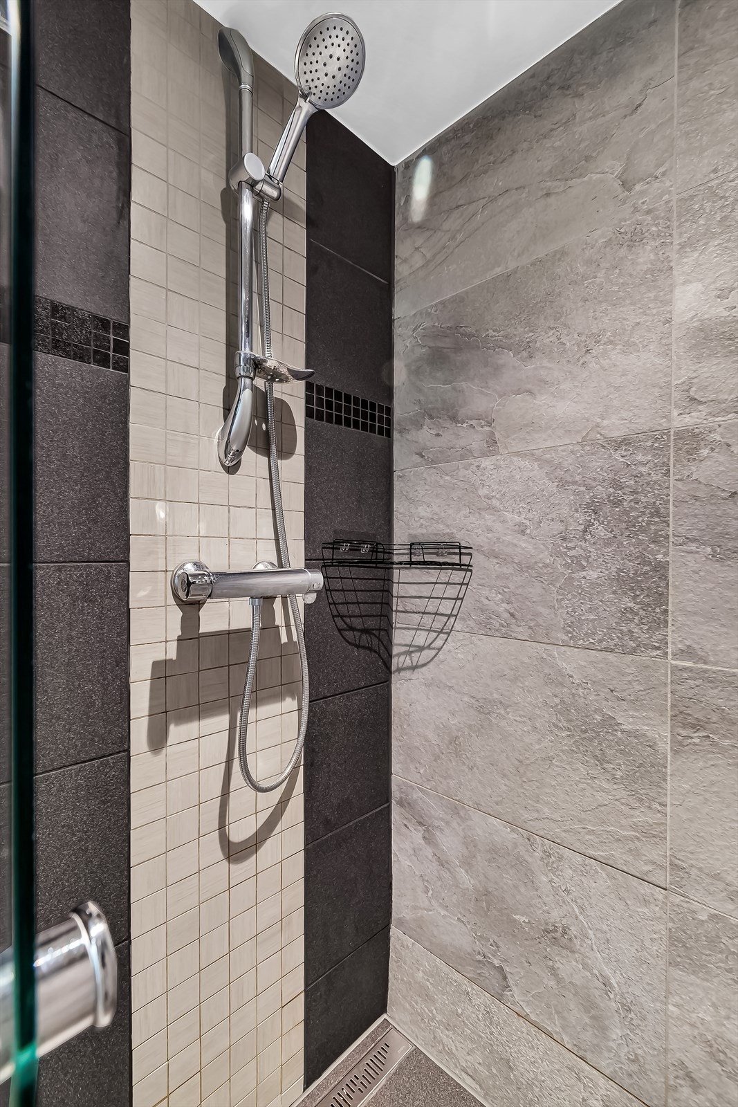 Badet er utstyrt med innfellbare dusjdører, mekanisk avtrekk, opplegg for vaskemaskin, servant og veggmontert wc. Galleribilde