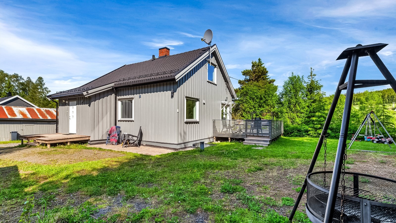 På tomten er det plen, trær og øvrig beplantning. Det står en låve, samt garasje og carport på eiendommen. Galleribilde