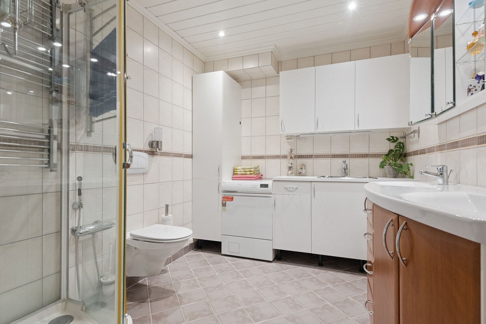 Fliselagt bad med vegghengt toalett, hygienedusj, dusjkabinett, dobbel servant. Gode vaskeromsfasiliteter. Galleribilde