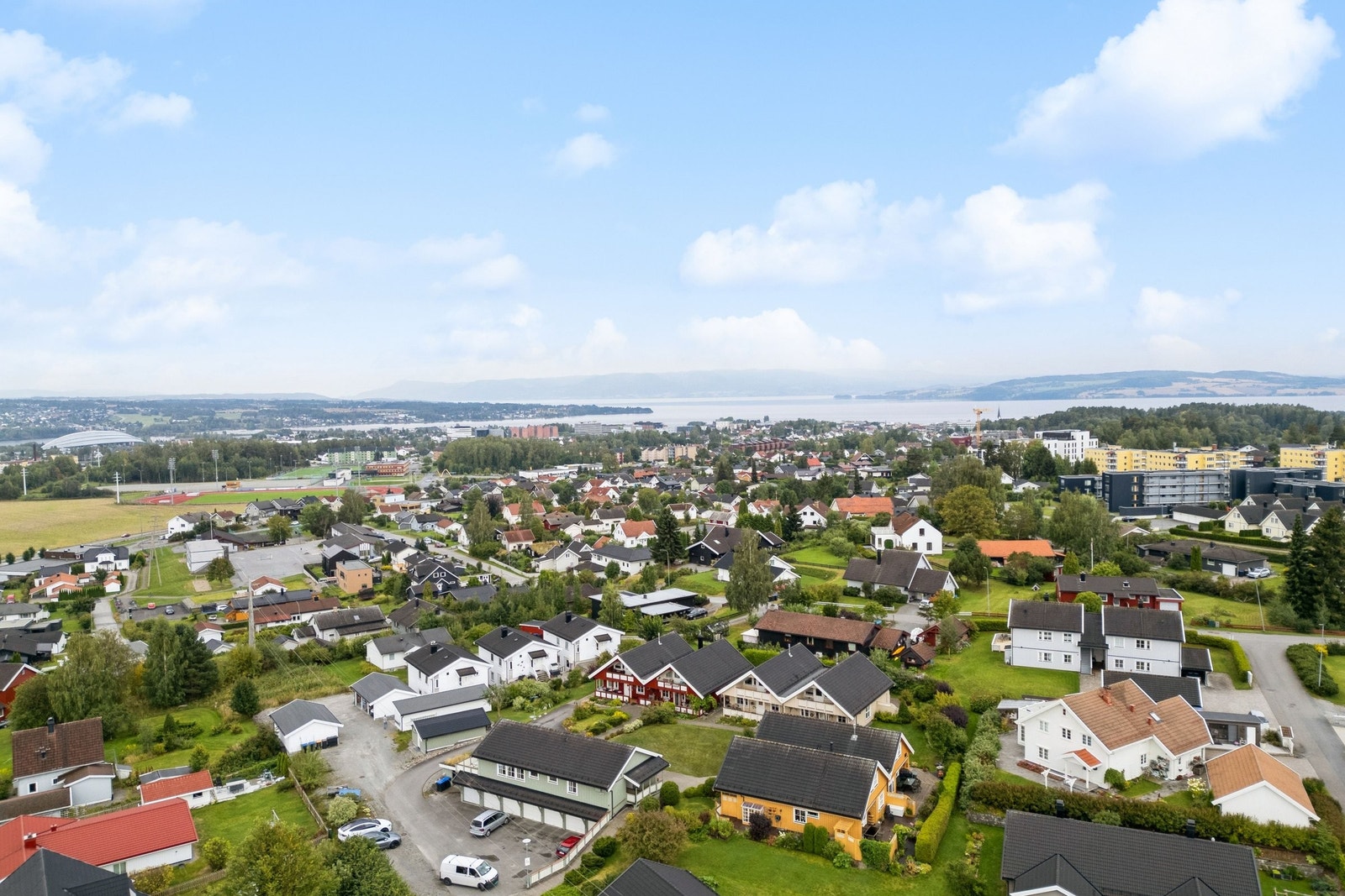 Oversikt over bebyggelsen. Felleshuset med garasjer i forgrunnen. Til venstre for det ser du et lite hus som er utebod som kan brukes til lagring av utemøbler, sykler, blomsterkasser, vinter- sommerdekk etc. Galleribilde