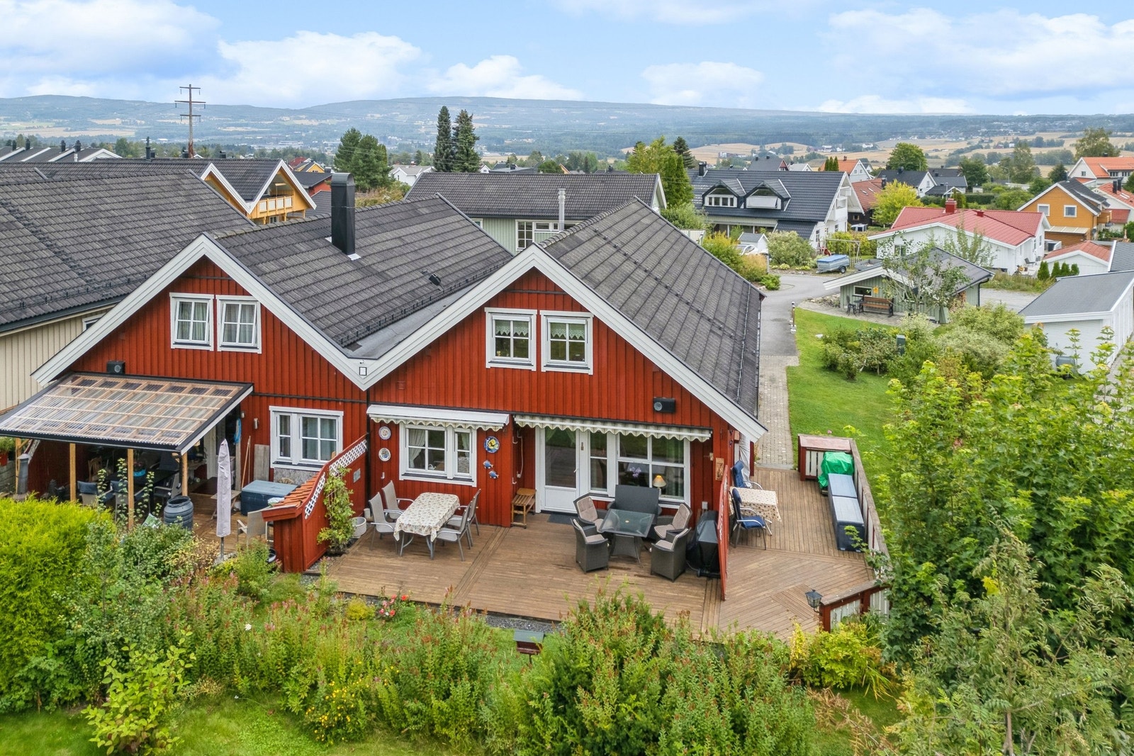 Skjermet terrasse med god plass til flere sittegrupper for å nyte solen gjennom hele dagen. Galleribilde