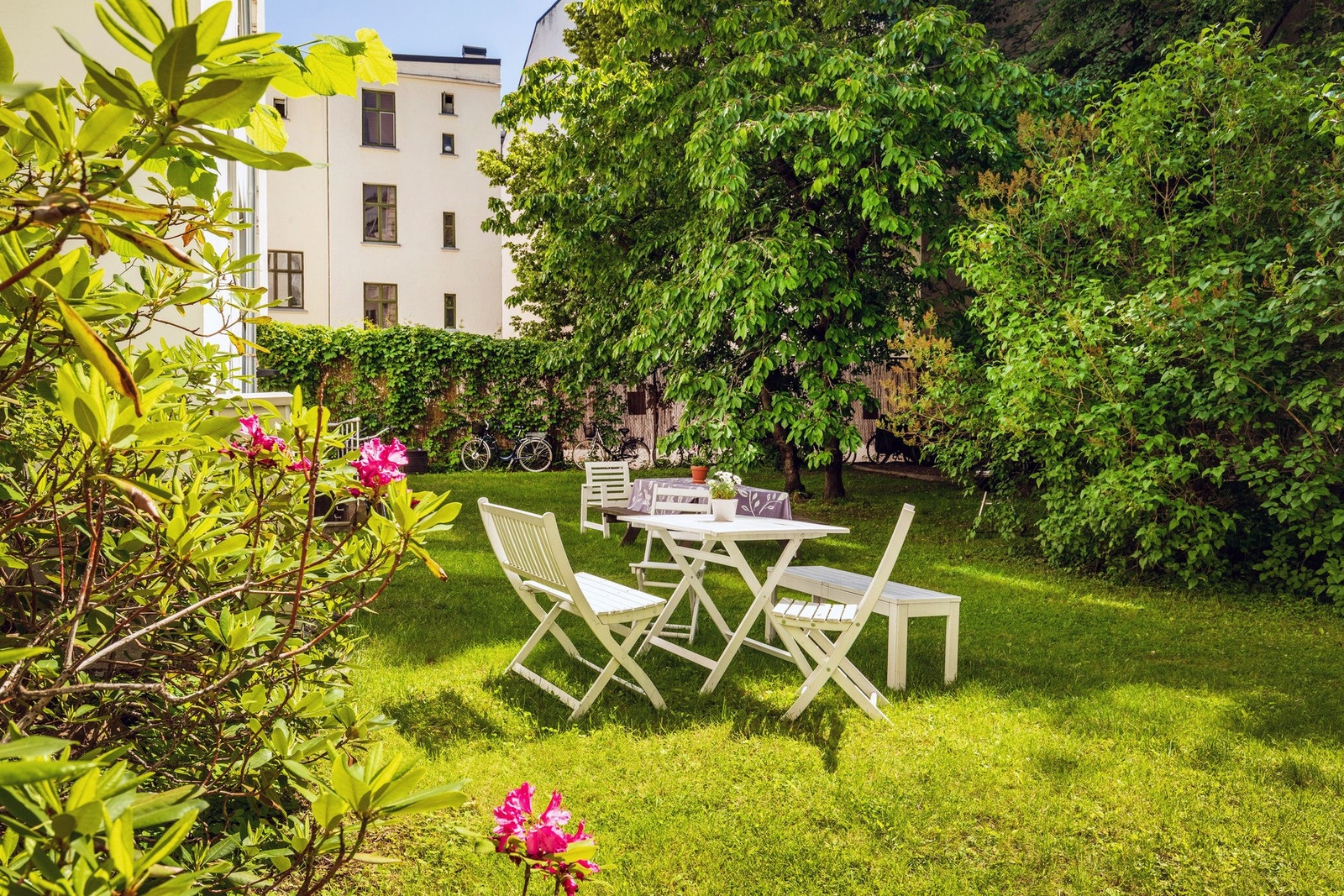 idyllisk grønn bakhage med sittegrupper, sykkelparkering og grill Galleribilde