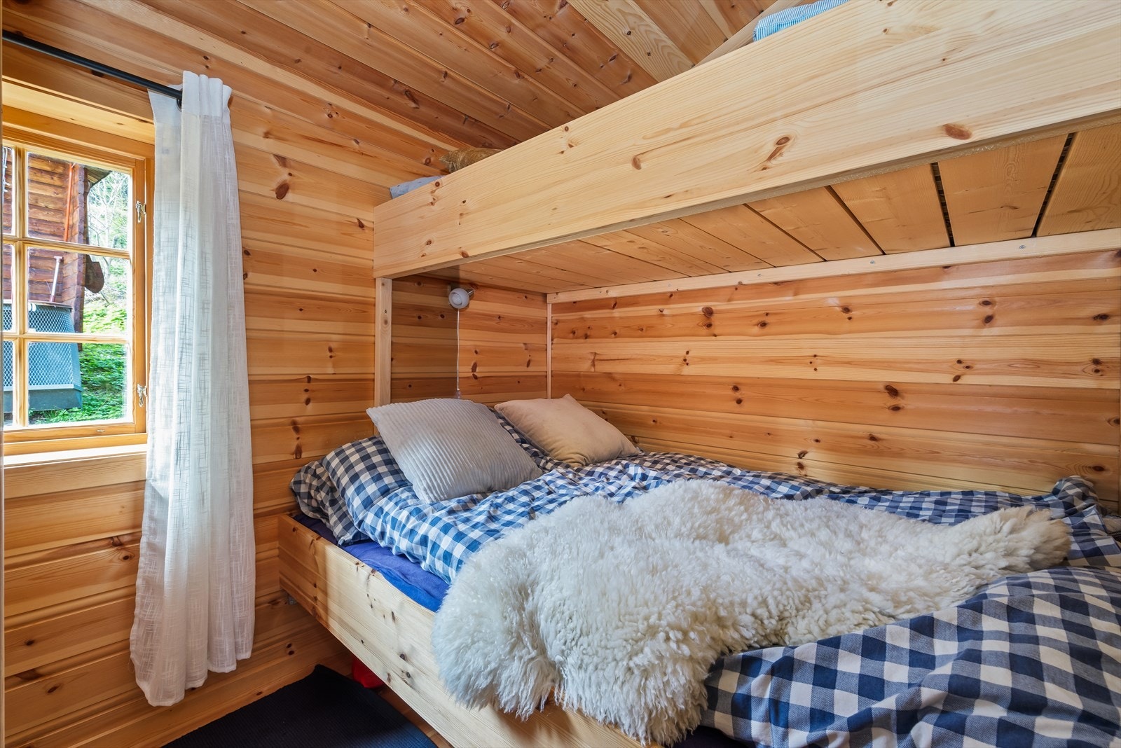 Den plassbygde soveromsløsningen er både praktisk og arealeffektiv, og passer perfekt inn i fritidsboligens stil og planløsning. Galleribilde