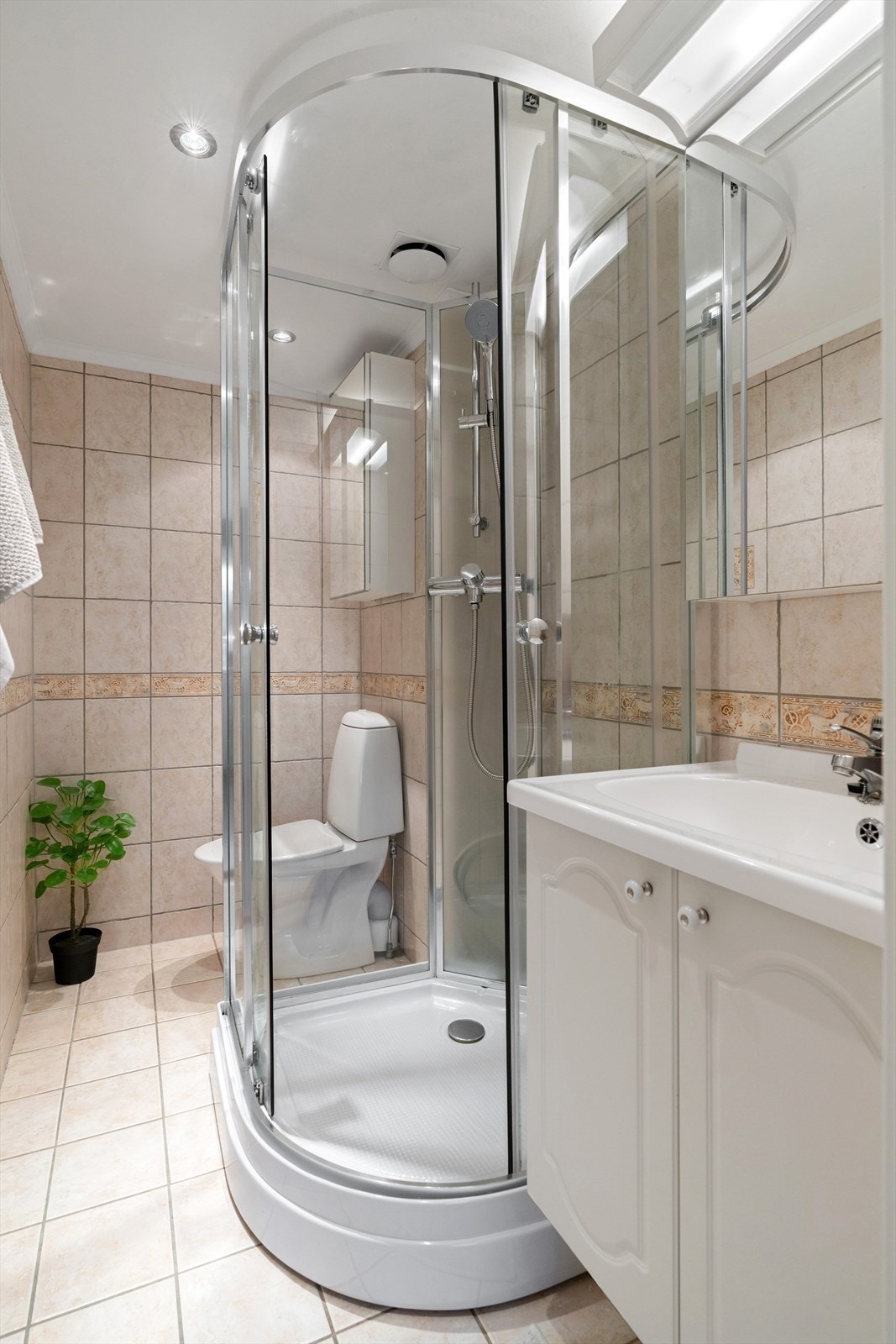 Badet har et flislagt gulv, vegg og malt slett himling. Galleribilde