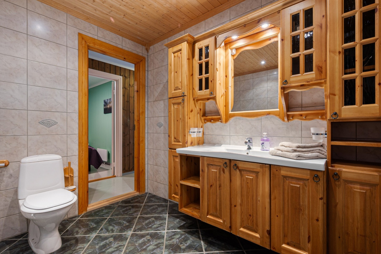 Romslig bad med lagringsrikt baderomsmøbel i heltre. Galleribilde