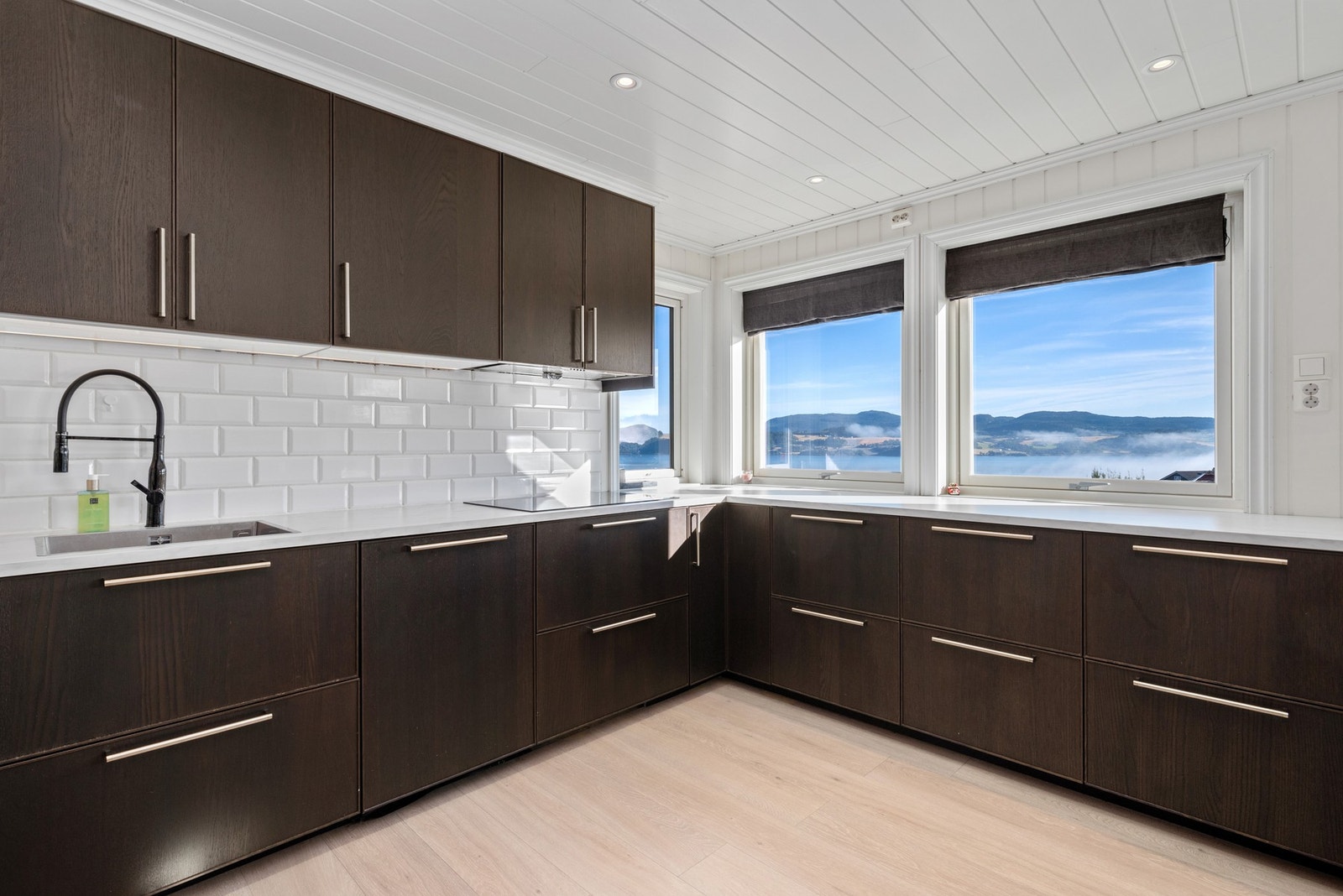 Kjøkkenet har gode arbeidsflater og rikelig med oppbevaring i en moderne innredning fra 2017. Galleribilde