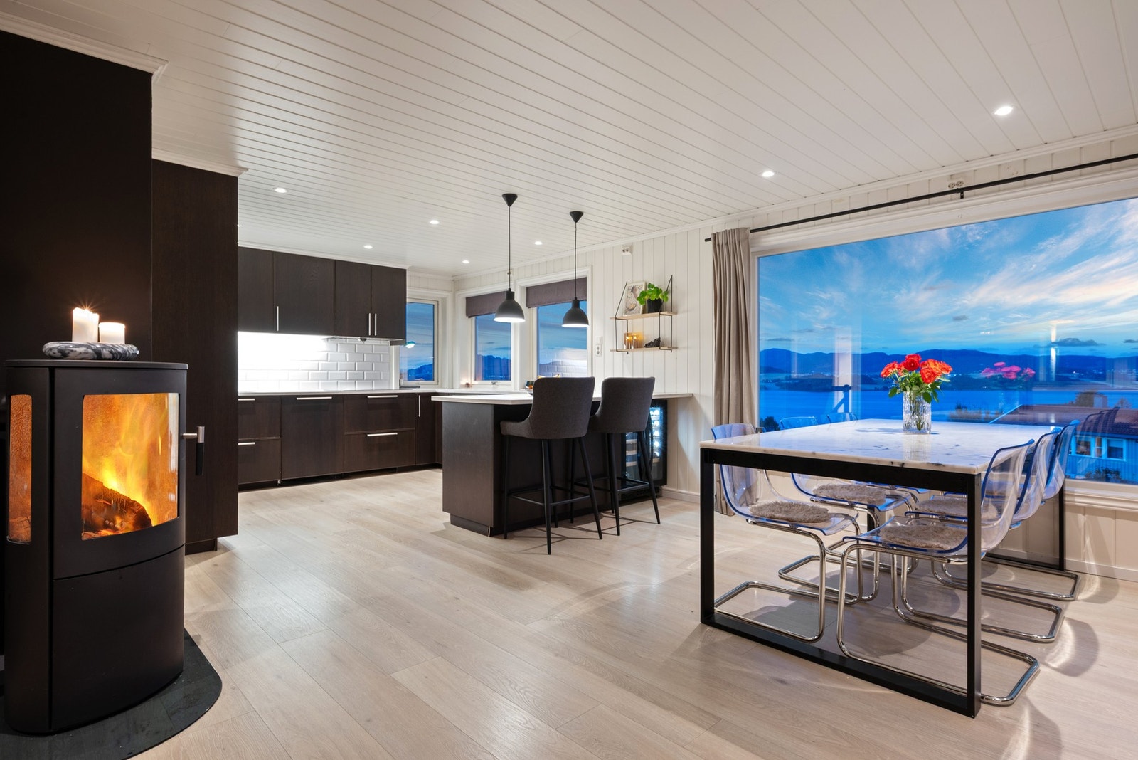 Lune kvelder sikres av en peisovn, plassert slik at den effektivt varmer opp hele rommet. Galleribilde