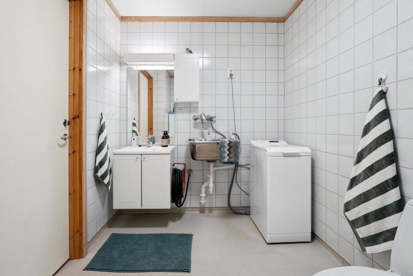 Badet er utstyrt med servant, skyllekar og opplegg for vaskemaskin. Galleribilde