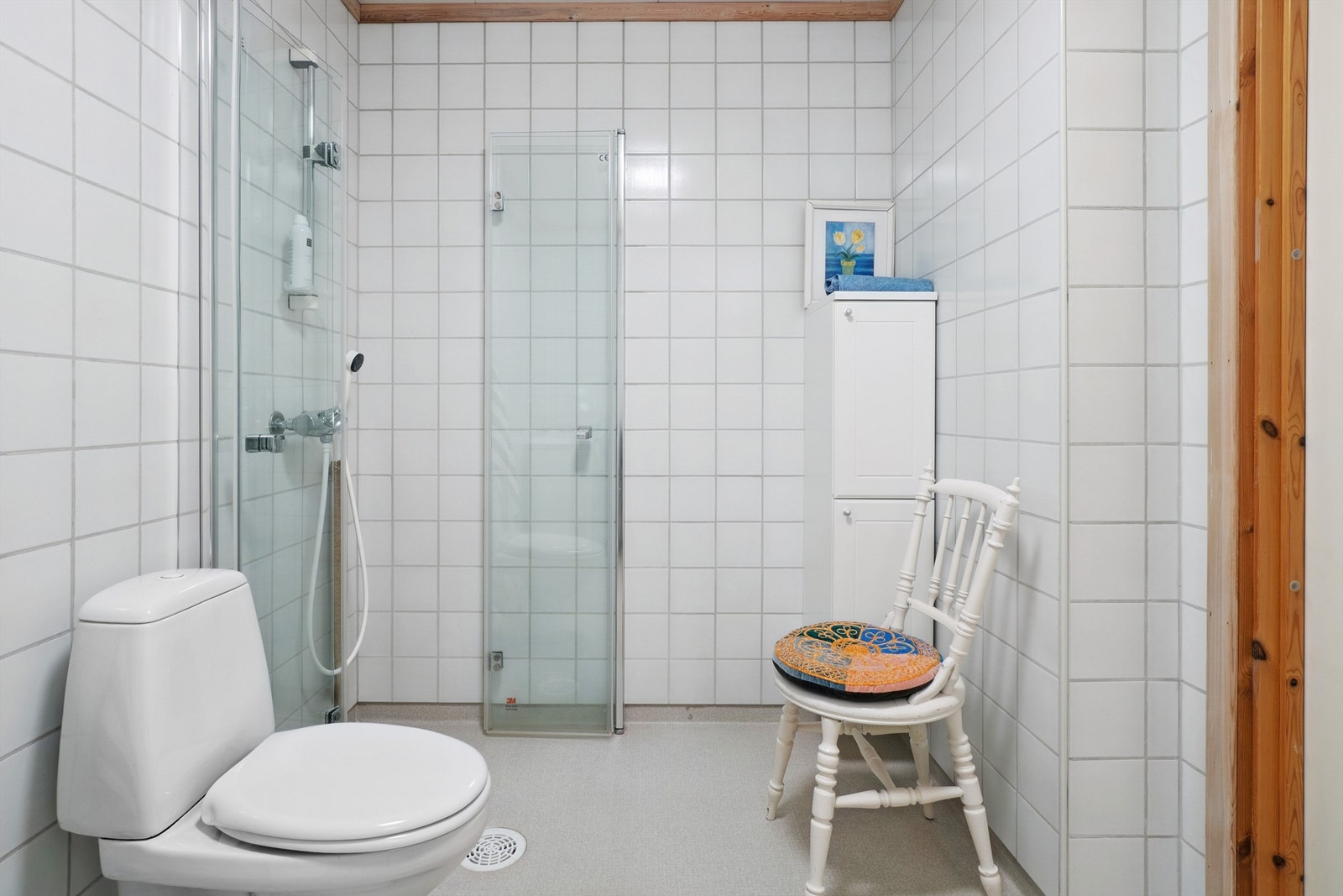 Flislagt bad med praktiske, innfellbare dusjdører som frigjør gulvplass. Galleribilde