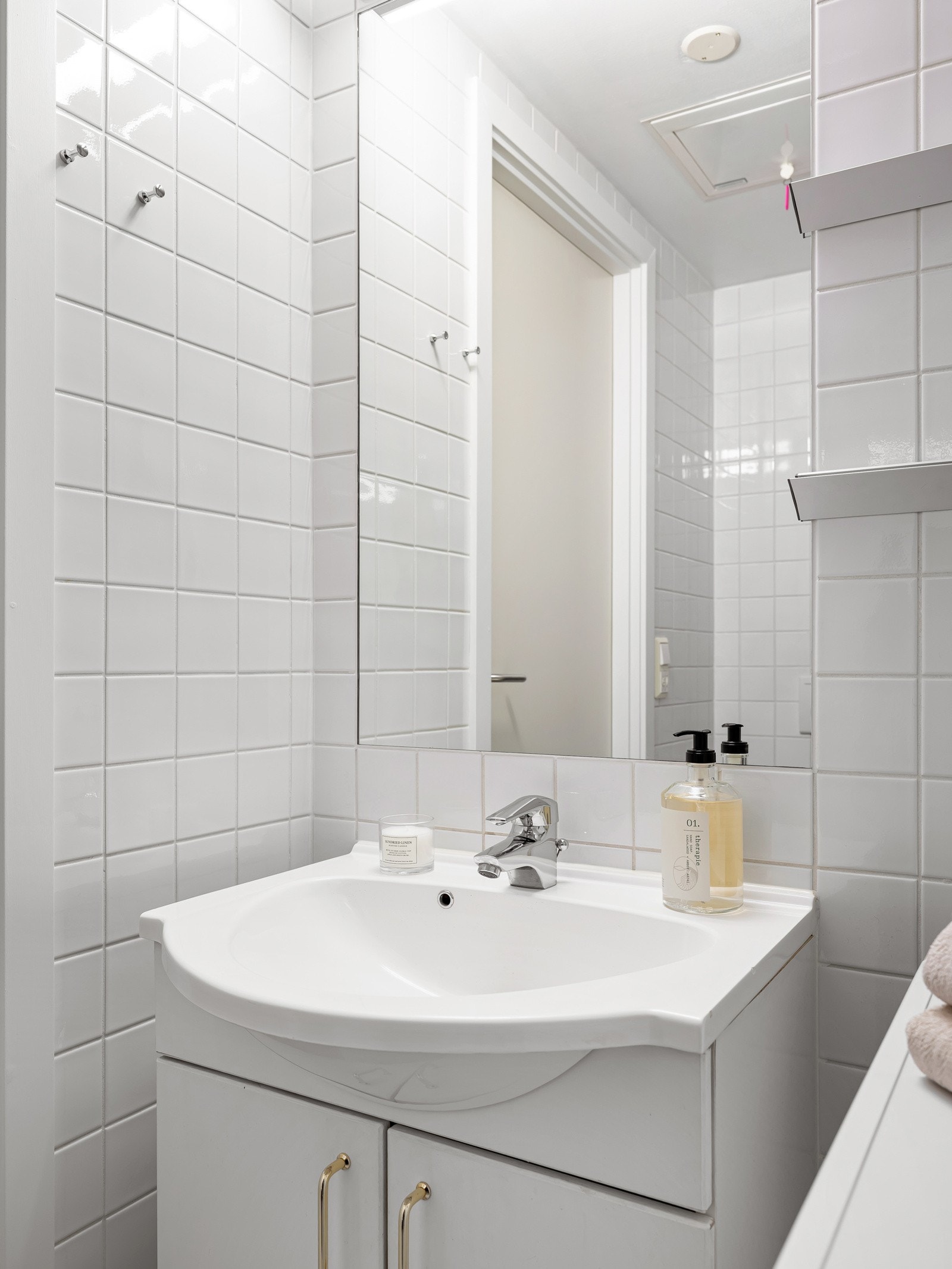 Rommet er innredet med servant med underskap, speil med lys, dusjhjørne med glassvegger, vegghengt toalett og opplegg for vaskemaskin. Galleribilde