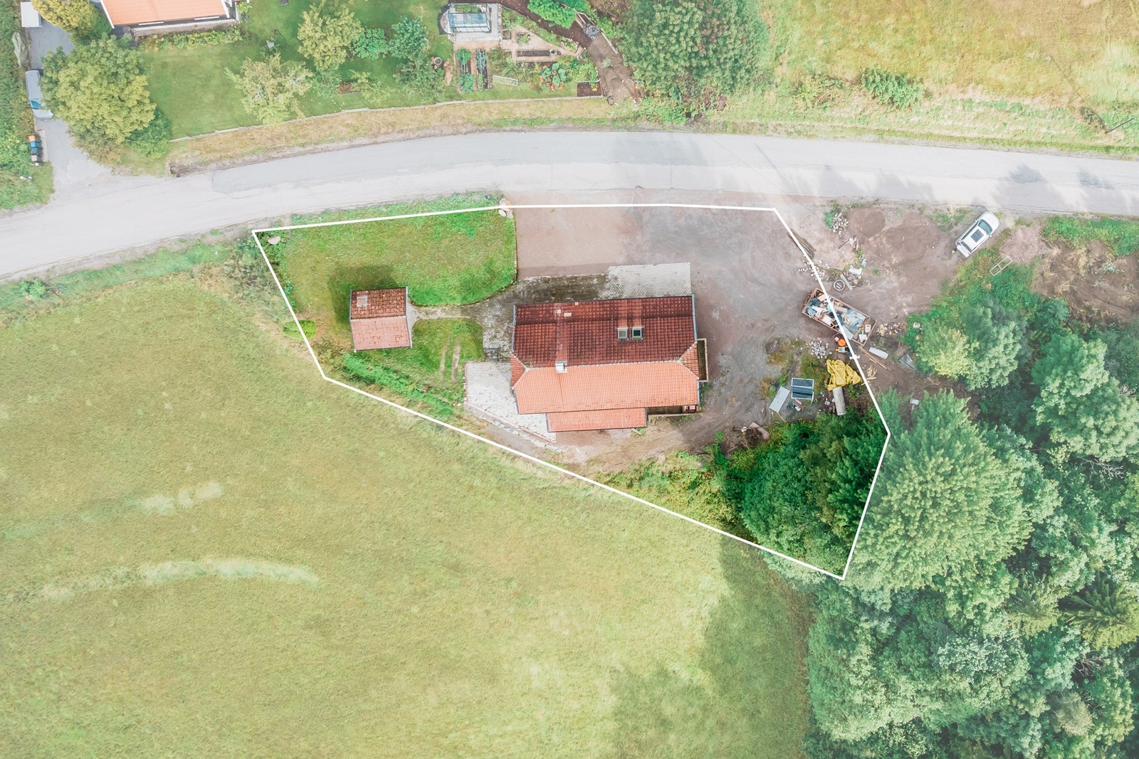 Stor tomt med gruset gårdsplass. Galleribilde