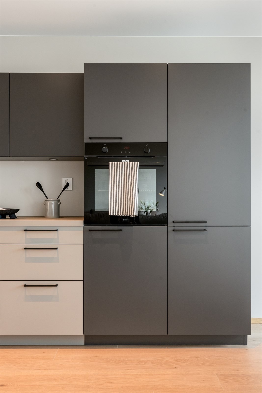 Kjøkkenet er moderne og praktisk, med god skap- og benkeplass. Det har en matt grå finish, og integrerte hvitevarer som kombiskap, oppvaskmaskin, stekeovn og koketopp. Galleribilde