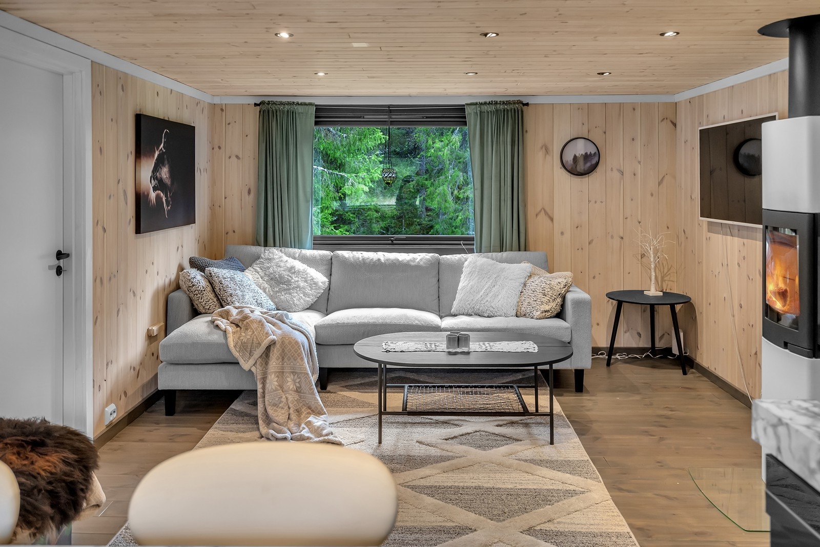 Boligen har isolert stålpipe og vedovn i stue. Galleribilde