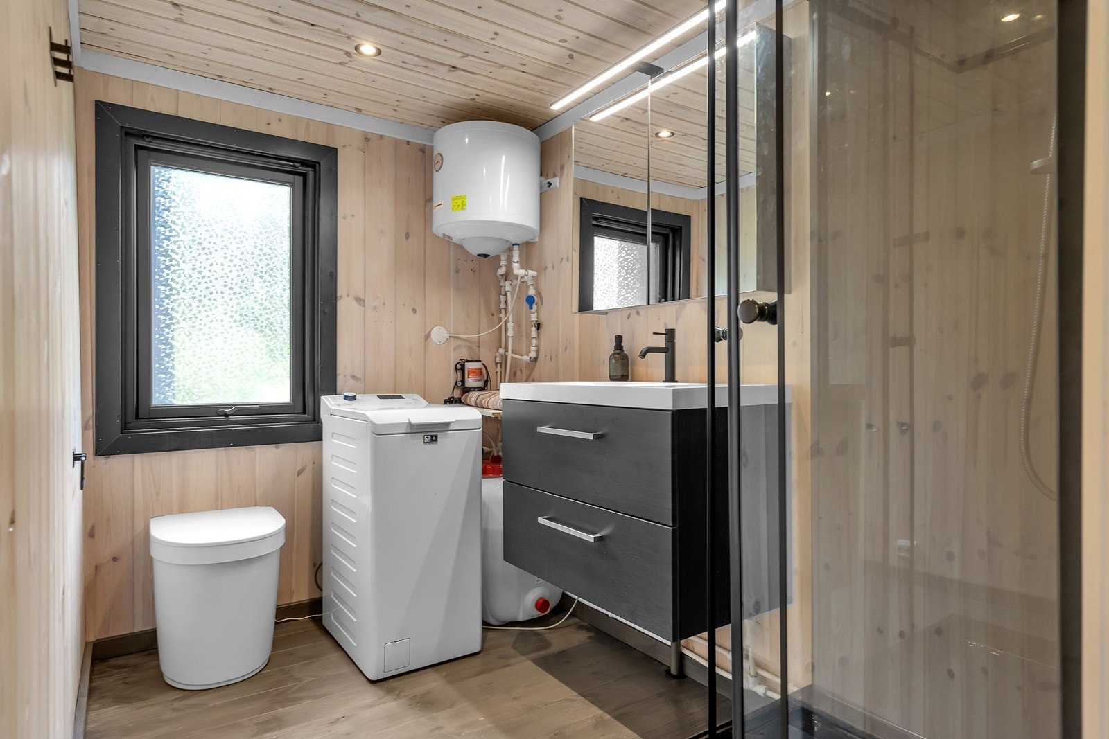 Toalettrom med innredning med vask og speil, dusjkabinett og Separett Tiny hyttetoalett. Galleribilde