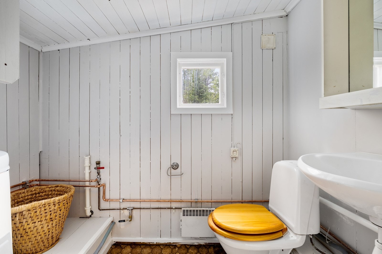 Toalettrom med opplegg for vaskemaskin og servant i rommet med speil Galleribilde