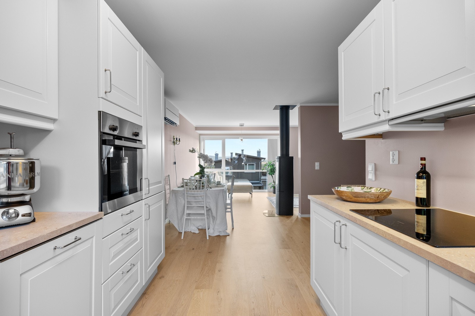 Innredet med hvite profilerte fronter, benkeplate i laminat og underlimt oppvaskkum. Galleribilde