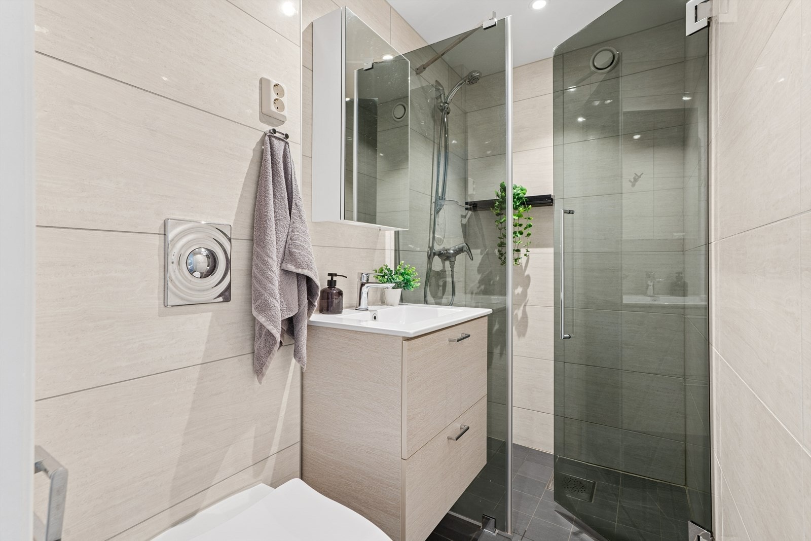 Flislagt baderom oppusset i 2010 med varmekabler i gulv, downlights i himling. Rommet har innredning med nedfelt servant, veggmontert toalett og dusjvegger/hjørne. Galleribilde