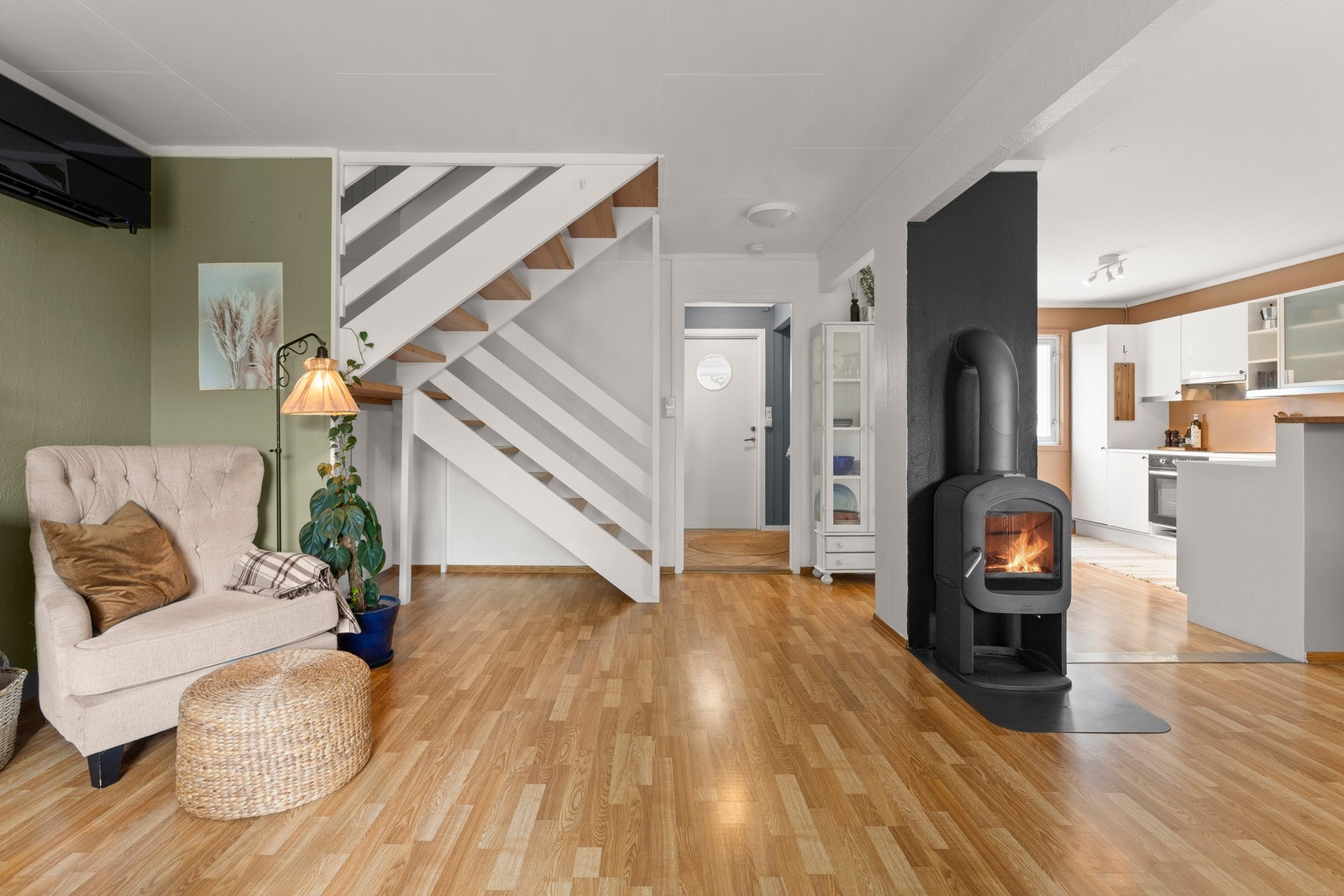 Stuen er i vinkel med kjøkkenet og gir naturlige soner for spisebord og sofakrok Galleribilde