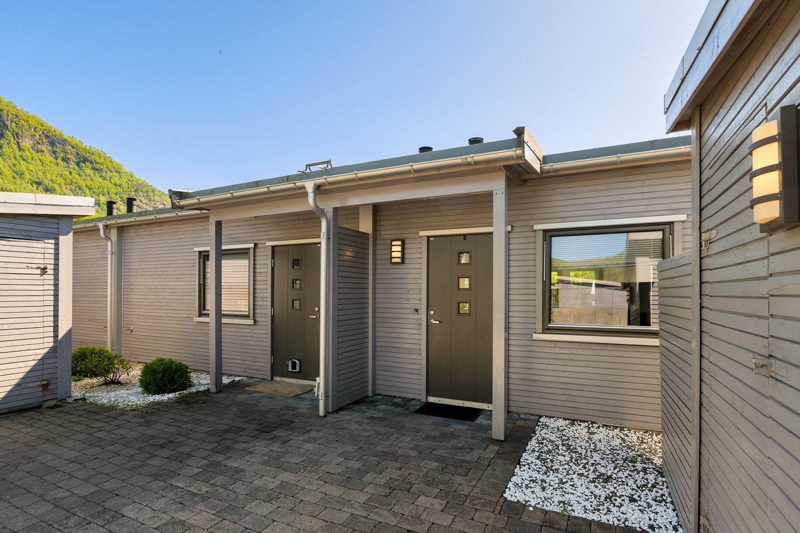 Steinlagt inngangsparti med takoverbygg. Galleribilde