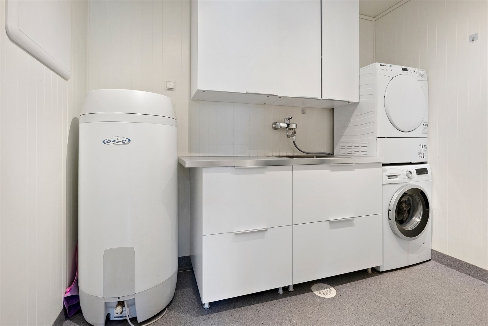 Praktisk vaskerom med benkeplate, god skapplass og opplegg for vaskemaskin. Galleribilde