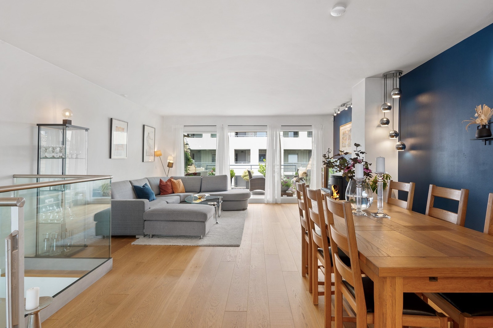 Stuen er luftig og fin med store vindusflater fra tak til gulv og utgang til leilighetens andre balkong. Galleribilde